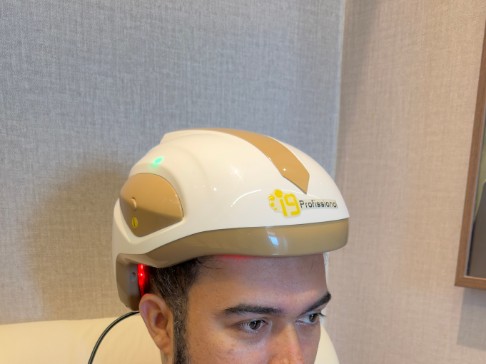 Paciente durante sessão de fototerapia por LED com capacete, na Clínica Levinê